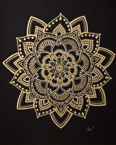 an intricate gold flower on black paper