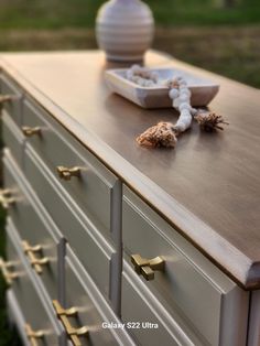 an antique dresser with brass handles and knobs is shown in front of a vase