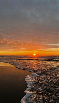 the sun is setting over the water at the beach