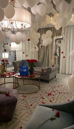 a room filled with lots of white balloons floating from the ceiling and on top of couches