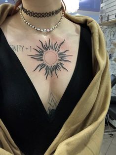 a woman with a sun tattoo on her chest