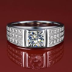 a white gold ring with a diamond center surrounded by smaller diamonds on a red background