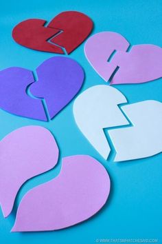 broken hearts cut out of paper on a blue background