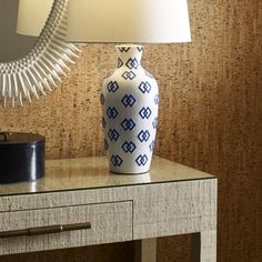 a blue and white vase sitting on top of a table next to a night stand