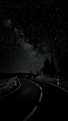 the night sky is filled with stars above a road