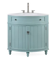 a bathroom vanity with a white sink and light blue wood cabinetry on the side