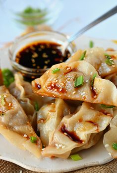 a white plate topped with dumplings covered in sauce