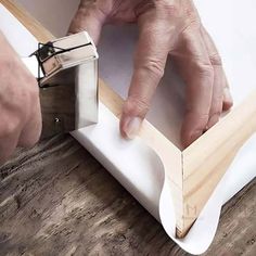 a person is working on a piece of wood with a pair of scissors and glue