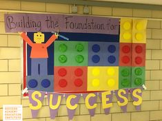 a bulletin board with legos on it that says building the foundation for success in front of a brick wall