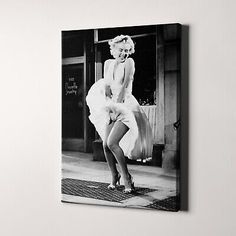 a black and white photo of marilyn monroe on a door mat in front of a store