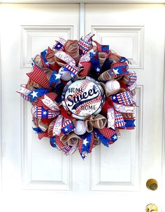 a wreath with baseballs and american flags on it is hanging on the front door