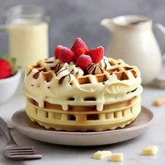 a waffle topped with whipped cream and raspberries next to a glass of milk