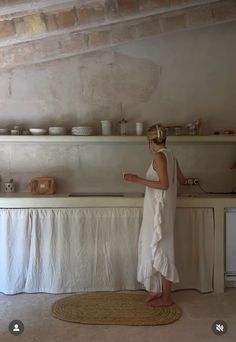 a woman standing in front of a kitchen counter