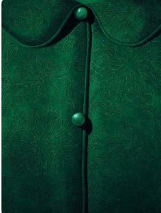 a green leather jacket with buttons on the front and back, in an intricate pattern