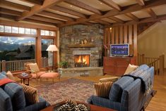 a living room filled with furniture and a flat screen tv mounted to a wall next to a fire place