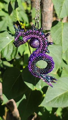 Hand beaded dragon using a mixture of Miyuki and Toho beads, woven around a 12mm galaxy tiger eye focal bead. Teal Dragon, Beaded Dragon, Purple Rainbow, Toho Beads, Tiger Eye Beads, Tourmaline Beads, Silver Line, Red Dragon, Focal Bead