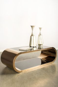 a modern coffee table with two vases on it's top and one side