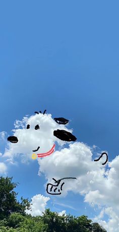 an image of a dog flying in the sky with trees and clouds behind it on a sunny day