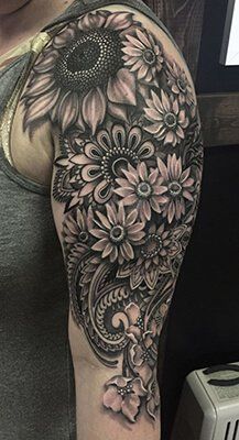 a woman's arm with sunflowers and flowers on it