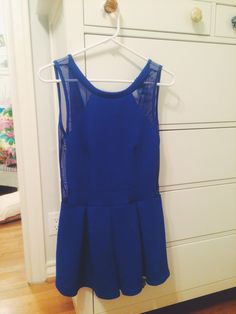 a blue dress hanging on a white dresser