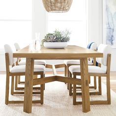 a wooden table with white chairs around it