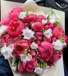 a bouquet of pink and white flowers sitting on top of a piece of paper