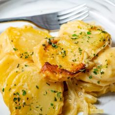 a white plate topped with ravioli and potatoes