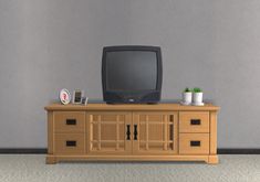 an old tv sitting on top of a wooden dresser next to a potted plant