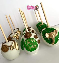 there are some cake pops decorated with animals and leaves on the top one is white