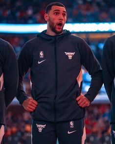 the chicago bulls are wearing black and white tracksuits while standing in front of an audience