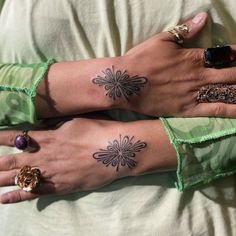 two women with matching tattoos on their hands