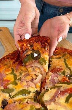 a woman is cutting into a pizza with ham, peppers and cheese on the top