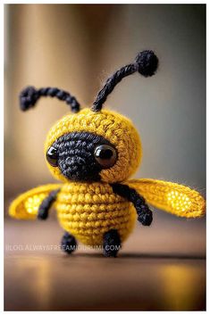 a small crocheted yellow and black bee sitting on top of a table