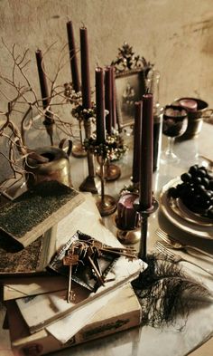 a table topped with lots of books and candles