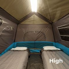 there are two beds in the inside of a tent that is pitched up to allow people to sleep