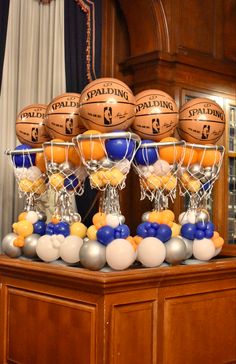 several basketballs and balloons on display in a room