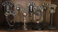 several microphones are lined up on a shelf