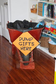 there is a sign that says dump gifts here in the wheelbarrow on the floor