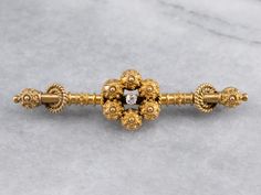 Dating to the late 1800s this beautiful brooch is crafted in the Etruscan style. Fantastic milligrain and wirework detail the classically styled frame, while the center is set with a twinkling old mine cut diamond! Love this piece but want to make it more versatile, we here at Market Square Jewelers along with our master metalsmiths can convert this fantastic brooch into a necklace or pendant for an additional fee, please contact us for more information! Metal: 14K Yellow Gold Gem: Old Mine Cut Victorian Brooch, Old Mine Cut Diamond, Market Square, Colored Gems, Wire Work, Eternity Bands, Diamond Cuts, Gold Rings, Vintage Jewelry