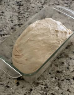 dough in a glass baking dish on a granite counter