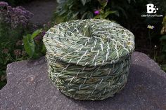 a basket sitting on top of a rock in a garden