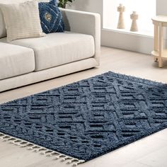 a living room with a white couch and blue rug