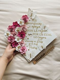 a hand holding a bouquet of flowers on top of a graduation cap that says congratulations