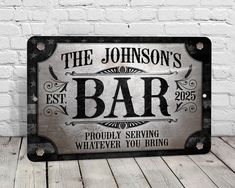 a metal sign that says the johnson's bar on it, sitting against a white brick wall