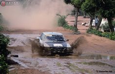 a car is driving through the mud on a dirt road