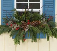 a window box filled with pine cones and greenery