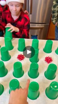 a child is playing with plastic cups on the table