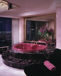 a bathroom with a pink bathtub and chandelier in the middle of it