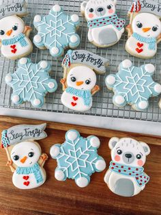 cookies decorated with frosting and icing are on a cooling rack next to a cookie tray