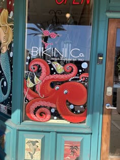 the front window of an art shop with octopus artwork on it's glass door